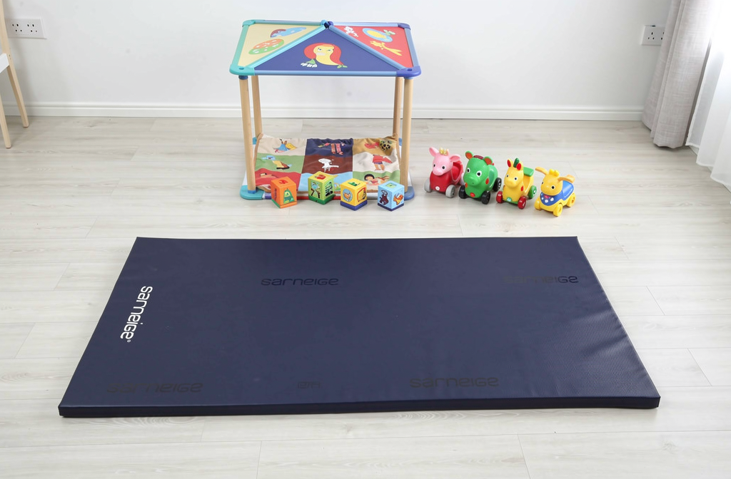 Tapis de sécurité bleu installé dans un coin jeux pour enfants.