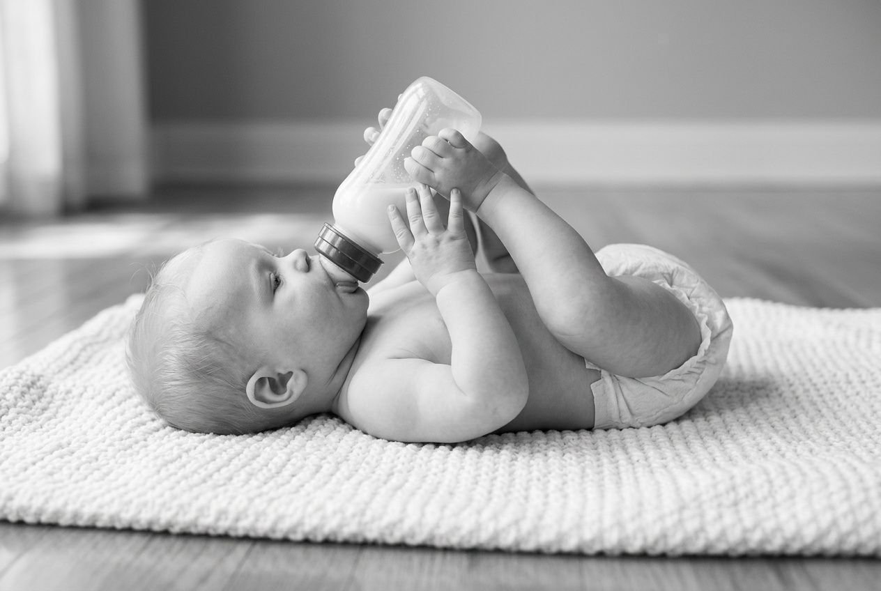 Zuigfles geven aan een slapende baby tijdens rustgevende, kalme verzorging : illustratie voor psychomotorische lesdoelstellingen.