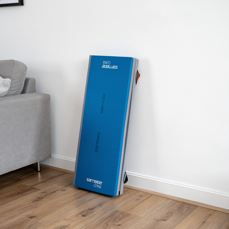 Opvouwbare turnmat compact opgeborgen in huiskamer hoek