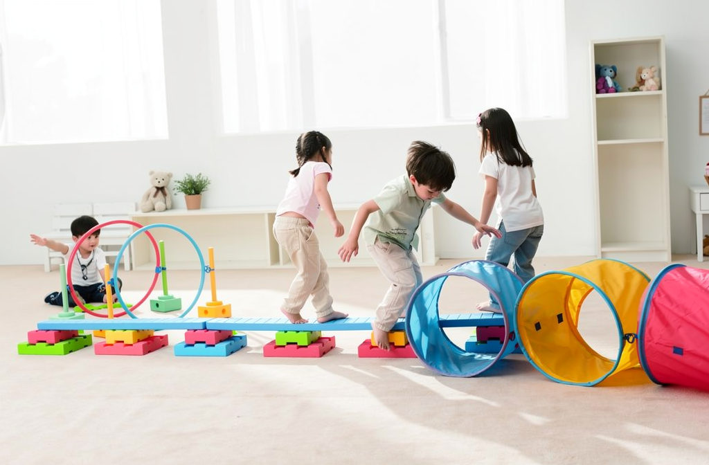 Kinderen oefenen samen met kleurrijk bewegingsparcours in een speelruimte