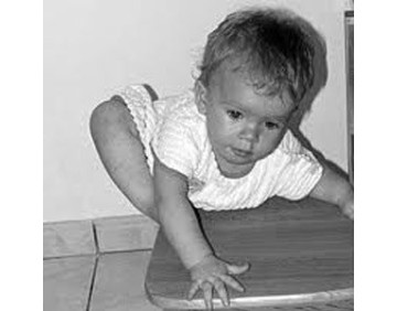 Enfant pratiquant un jeu de psychomotricité sans matériel sur le sol