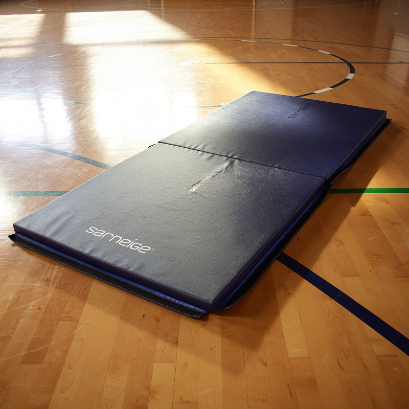 Tapis de gymnastique Sarneige posé sur les lignes d'un terrain de sport dans un gymnase scolaire
