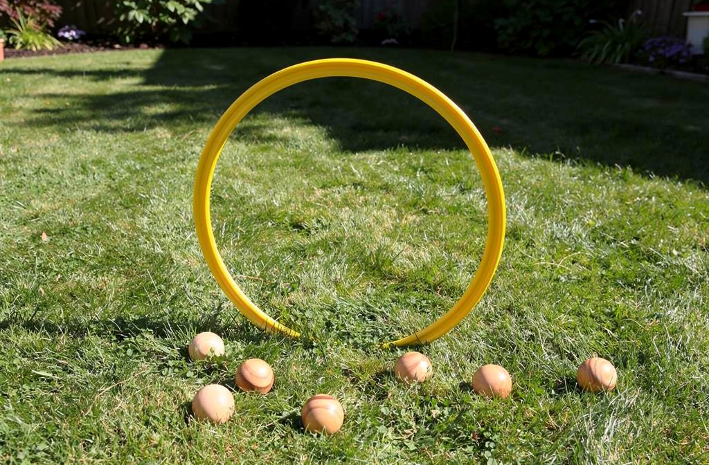 Cerceau jaune dressé sur l'herbe pour jeu d'adresse extérieur avec balles